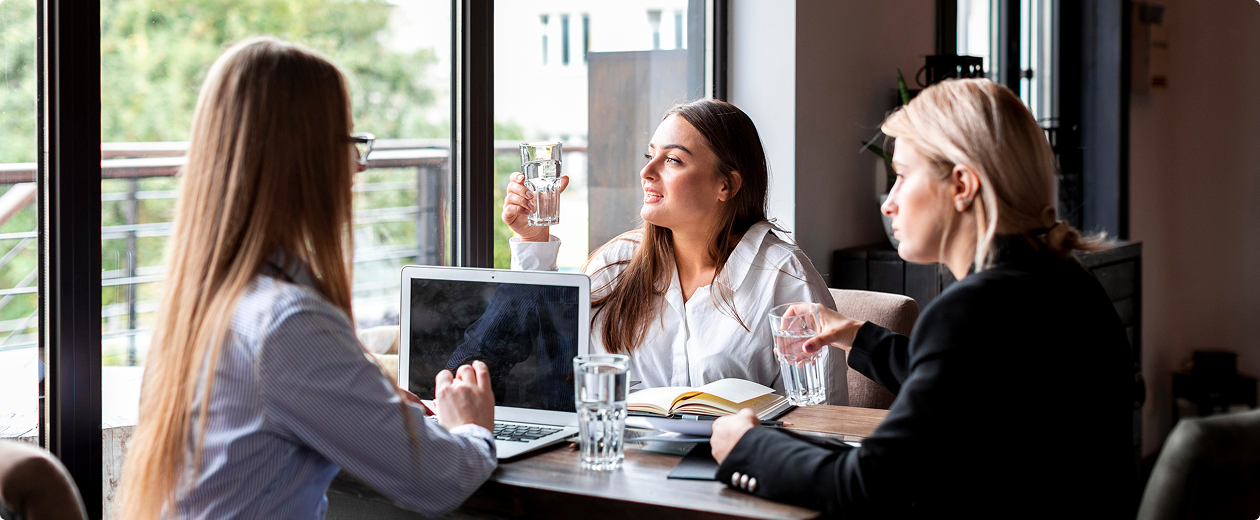 Executive coach leading a leadership development discussion with professionals at meeting table