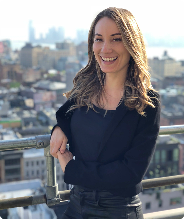 Certified executive coach smiling on balcony with city skyline background